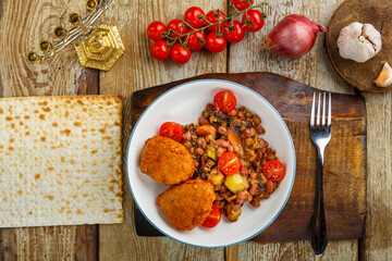 Cod cutlets with potatoes and vegetables on a round stand next to the ingredients.