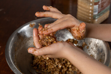 Liittle girl hands preparing oatmeal chocolate chips cookies