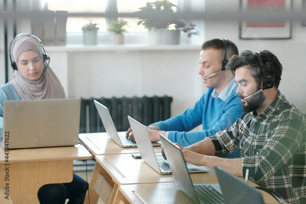 Poster Group of young operators consulting clients online while working in office