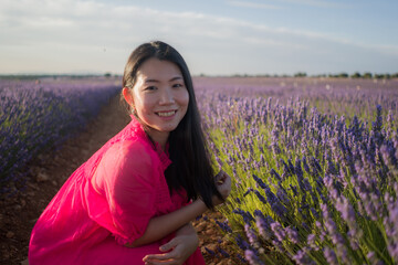 young Asian woman outdoors at lavender flowers field - happy and beautiful Japanese girl in sweet...