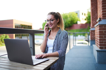 Happy female freelancer checking received email on laptop and calling to friend for discuss good...