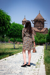 Fashionable beautiful  handbag on the arm of the girl in a fashionable  dress.