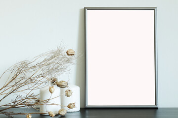 mockup for pictures and arts, blank frame on the table with white candles and dry flowers