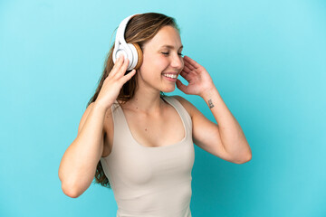 Young caucasian woman isolated on blue background listening music and singing