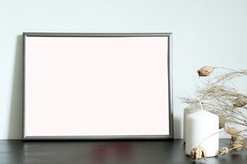blank a4 horizontal frame on the table with candles and dry flowers