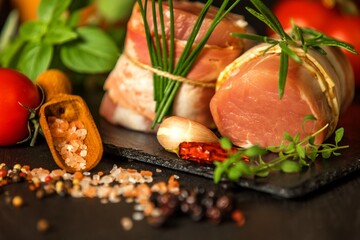 Fresh raw pork tenderloin with bacon on slate board. Meat ready for grilling. Diet food.