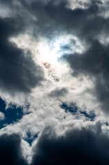 Cloudy skies with white-gray rain clouds obscured sky and bright sun.