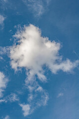 Obraz premium Bright blue sky with small white cloud disappearing from sun's heat.