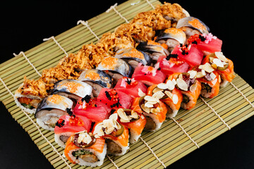 Sushi and soy sauce in a bowl and wooden chopsticks on a gray wooden table. Japanese food. Sushi...