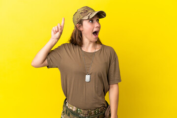 Military caucasian woman with dog tag isolated on yellow background intending to realizes the...