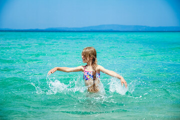 happy child at sea in greece plays in nature