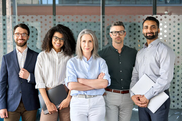 Happy diverse business people team standing together in office, group portrait. Smiling multiethnic international young professional employees company staff with older executive leader look at camera. - Powered by Adobe