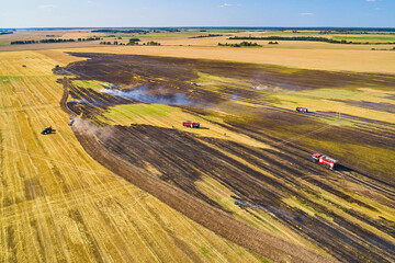 Rescuers extinguish a small fire in the field.