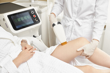 Young woman making body hair removal laser depilation in beauty center