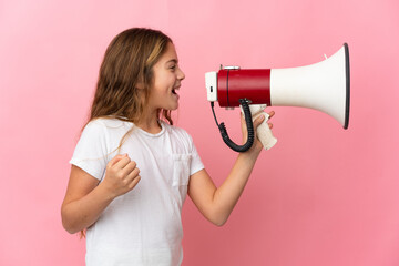 Child over isolated pink background shouting through a megaphone to announce something in lateral position