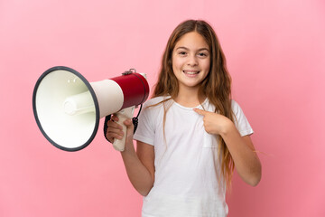 Child over isolated pink background holding a megaphone and with surprise facial expression