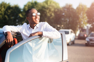 happy african american next to a car in the summer - 447357074