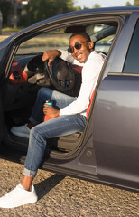 happy african american driving a car with coffee, in the summer - 447357260