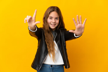 Child over isolated yellow background counting seven with fingers