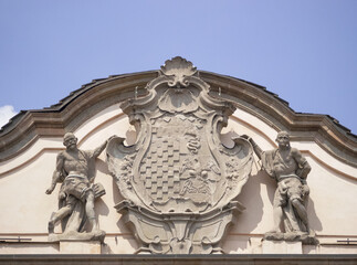 Moorish statues hold up the Litta family coat of arms on the Rococo facade of the ancient palace in Milan, Italy