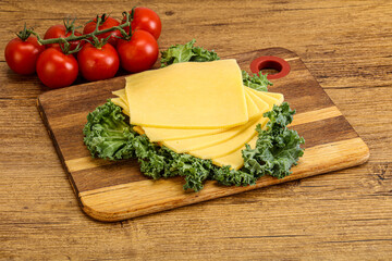 Sliced Gauda cheese over board