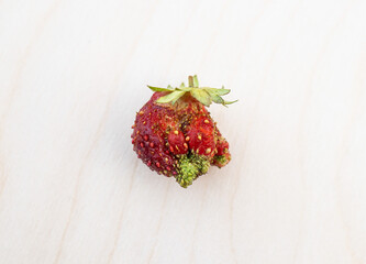 Ugly formless strawberry isolated on white background. Misshapen produce