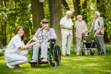 Happy nurse and elder woman on the wheelchair