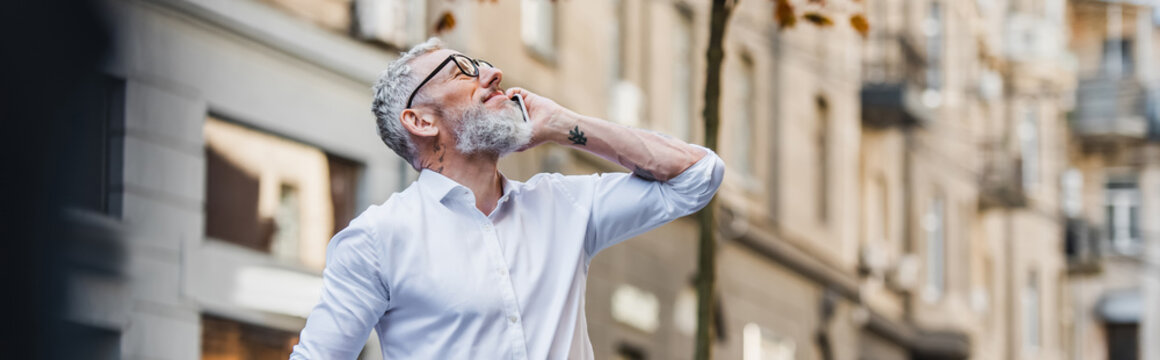 Happy Middle Aged Man In Glasses Talking On Smartphone And Looking Up, Banner