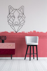 Pastel grey velvet chair next to stylish commode with pastel pink and burgundy drawers