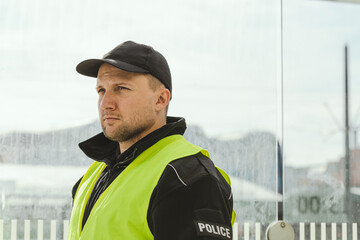 Obraz premium Handsome police officer wearing black uniform and reflecting vest