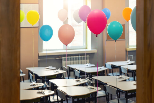 Entrance Door Of Empty Elementary Primary School Interior Furniture Children Desk Decorated With Multicolored Colorful Air Balloons Against Window. Happy Knowledge Day And Back To School Concept