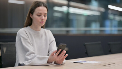 Fototapeta na wymiar Attractive Woman using Smartphone at Work