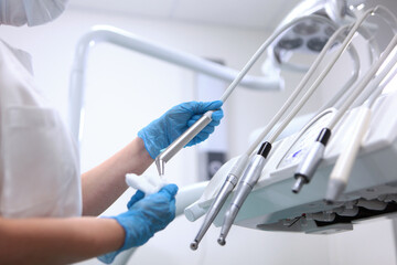 Disinfection of dental equipment. The dentist's assistant wipes the movable instrument shelf....