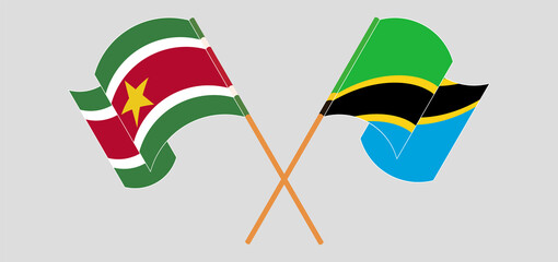 Crossed and waving flags of Suriname and Tanzania