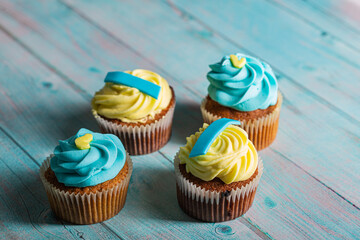 Blue and yellow handmade muffins on a blue wooden background
