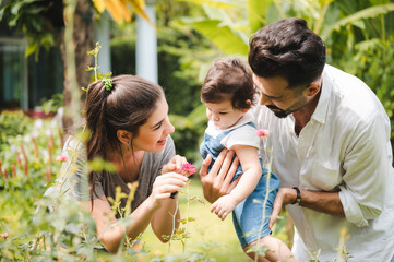 Obraz premium happy family at home together concept, children joying with father and mother on summer nature garden outdoors, people having fun, boy or girl and young woman are smiling lifestyle outside the park