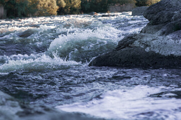 Background, top view, rapid flow river with dark blue water and white foam waves