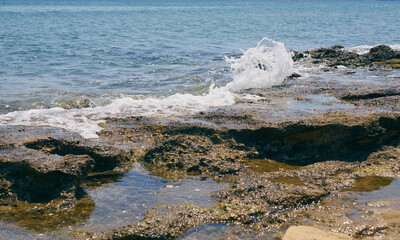 Waves with foam on Aegean sea coast in Crete Greece.