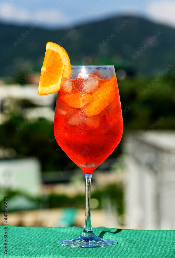 Sticker glass of cold refreshing cocktail with ice and fresh orange slice