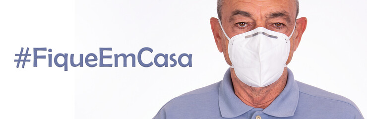 text stay at home in portuguese with elderly man wearing protective mask against covid-19
