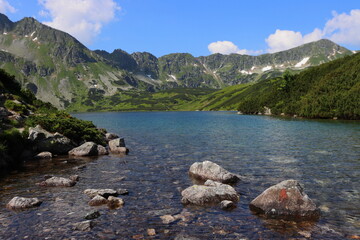 The Tatras. Polish mountains in summer, the peaks of the Tatra Mountains, a pond in the mountains. Valley of the Five Polish Ponds. Landscape of the mountains and the pond.