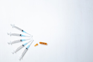 A hypodermic injection syringe. Syringes with blue needles and a broken brown ampoule. Medical Injectors.