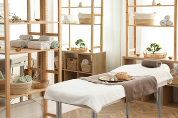 Fototapeta na wymiar Stylish room interior with massage table in spa salon