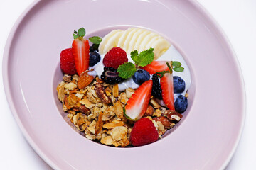 granola bowl with yoghurt, banana and fresh assorted berries. healthy breakfast concept