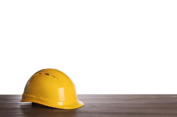 Yellow hard hat on wooden table against white background. Space for text