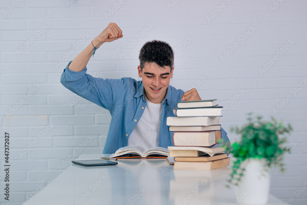 Poster student at the desk with book and expression of success and triumph