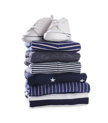 Stack of clean baby's clothes and small shoes on white background
