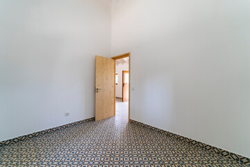 Empty room with hydraulic ceramic tile floor. House interior, wide bedroom or living room space....