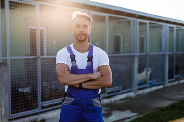 Young handsome adult male worker in animal shelter holding adorable dogs..