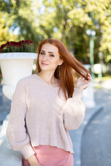 portrait of a young woman with red hair. walk in the park